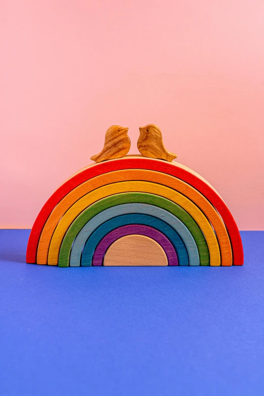 two birds sitting on top of a rainbow, new sculpture, wooden art toys, with great domes and arches, product shot, cuddling