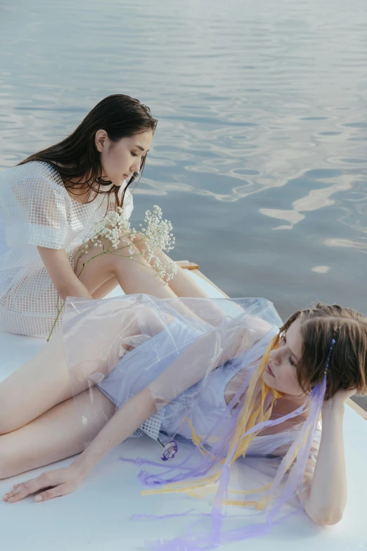 a couple of women laying on top of a boat, inspired by Ren Hang, trending on pexels, translucent dress, sweet looks, guweiz, low detail