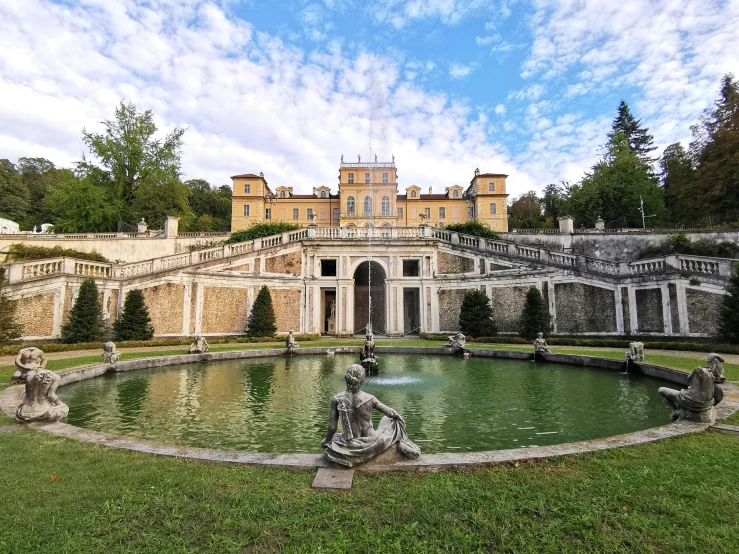 a large building with a fountain in front of it, an album cover, inspired by Serafino De Tivoli, pexels contest winner, rococo, lake view, vouge italy, exterior view, lawn