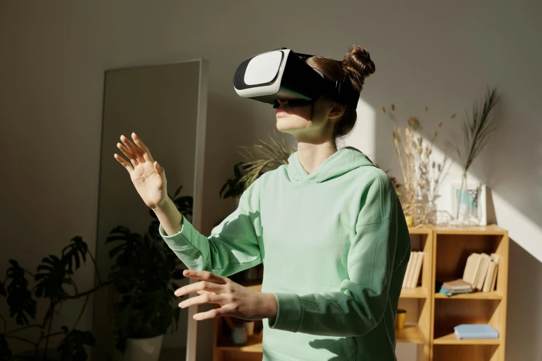 a woman wearing a virtual reality headset in a living room, trending on pexels, waving, student, virtual installation, avatar image