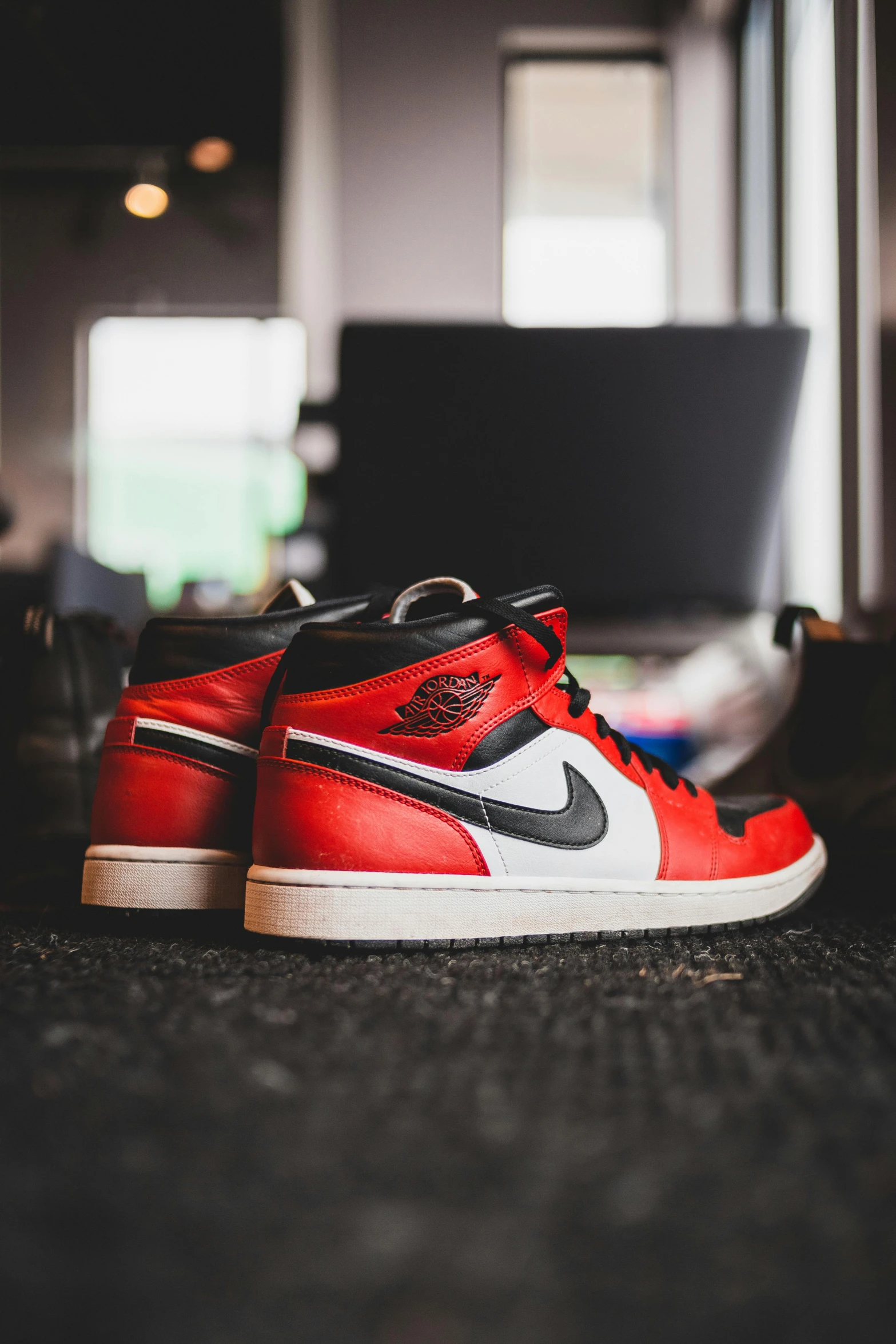 a pair of sneakers sitting on top of a carpet, a picture, inspired by Jordan Grimmer, trending on pexels, red and white and black colors, profile shot, game ready, standing on a desk