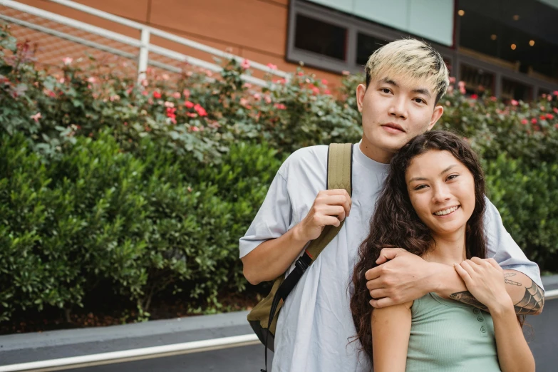 a man and a woman standing next to each other, a photo, trending on pexels, a young asian woman, non-binary, hugging, 15081959 21121991 01012000 4k