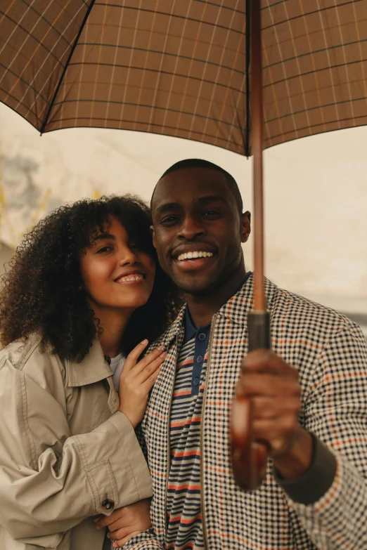 a man and a woman standing under an umbrella, trending on pexels, with brown skin, wholesome, kodak film, feels good man