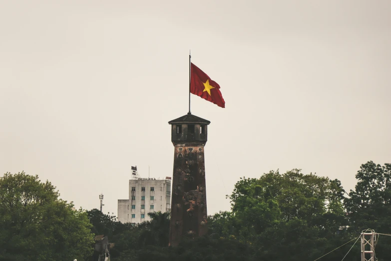 a tall tower with a flag on top of it, pexels contest winner, vietnam war, square, brown, grey