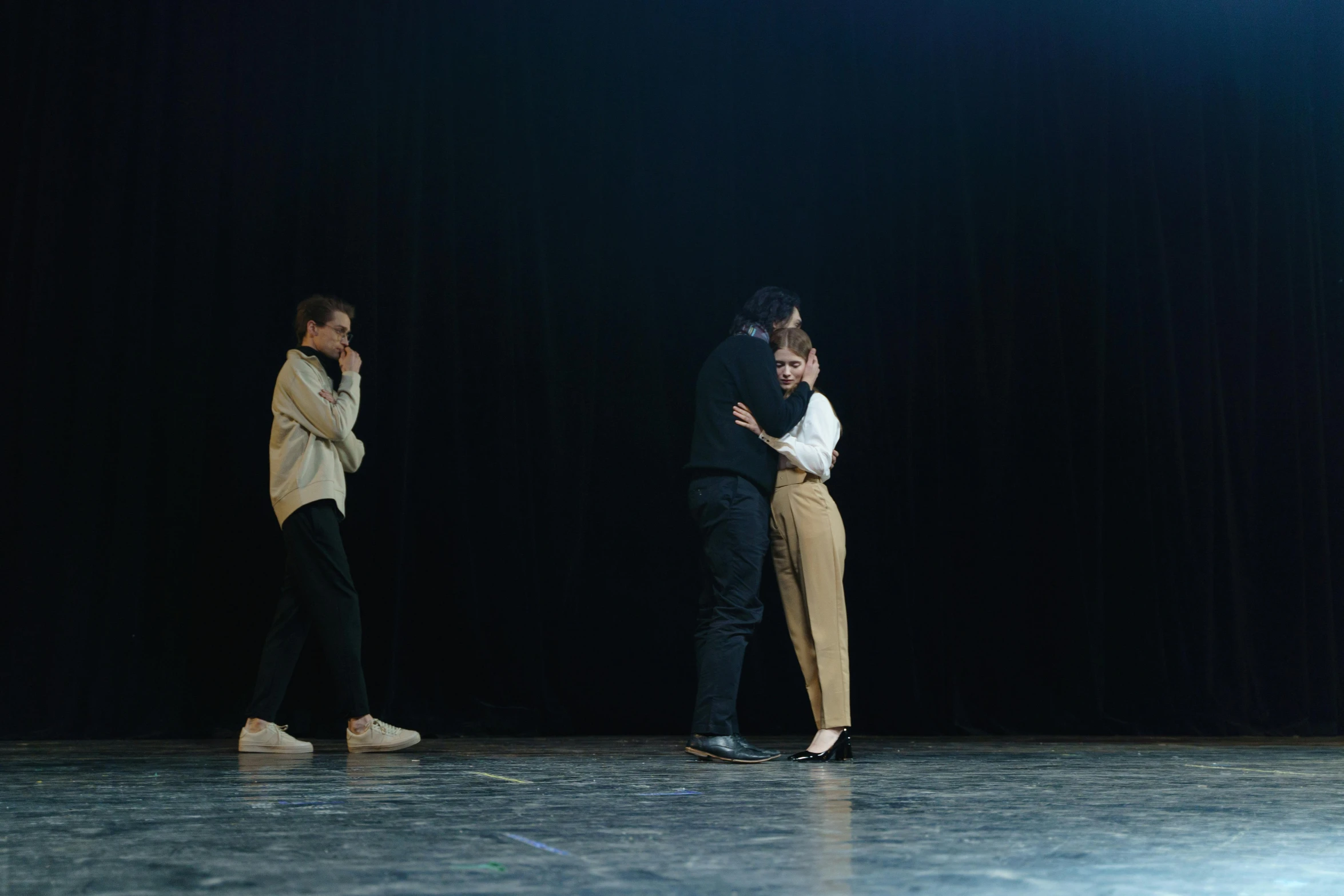 a group of people standing on top of a stage, a portrait, by Emma Andijewska, unsplash, antipodeans, hugging his knees, 3 actors on stage, ignant, she's sad