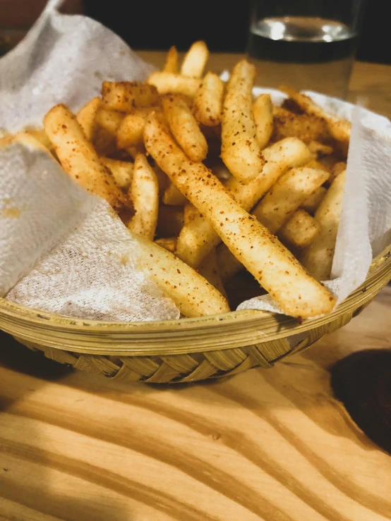 a basket of french fries sitting on top of a wooden table, thumbnail, cinnamon, not cropped, dessert