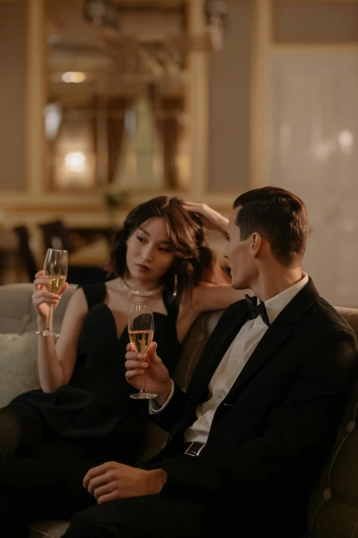 a man and a woman sitting on a couch holding wine glasses, long luxurious gown, alessio albi and shin jeongho, sydney hanson, profile image