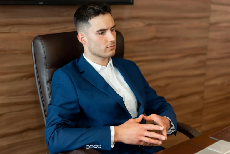 a man in a blue suit sitting at a desk, style of maciej kuciara, proffesional