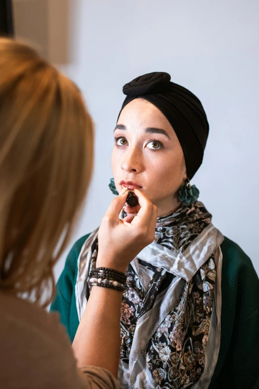 a woman brushing her teeth in front of a mirror, inspired by Alberto Morrocco, pexels contest winner, hurufiyya, wearing a head scarf, kiko mizuhara, fashion week backstage, prosthetic makeup