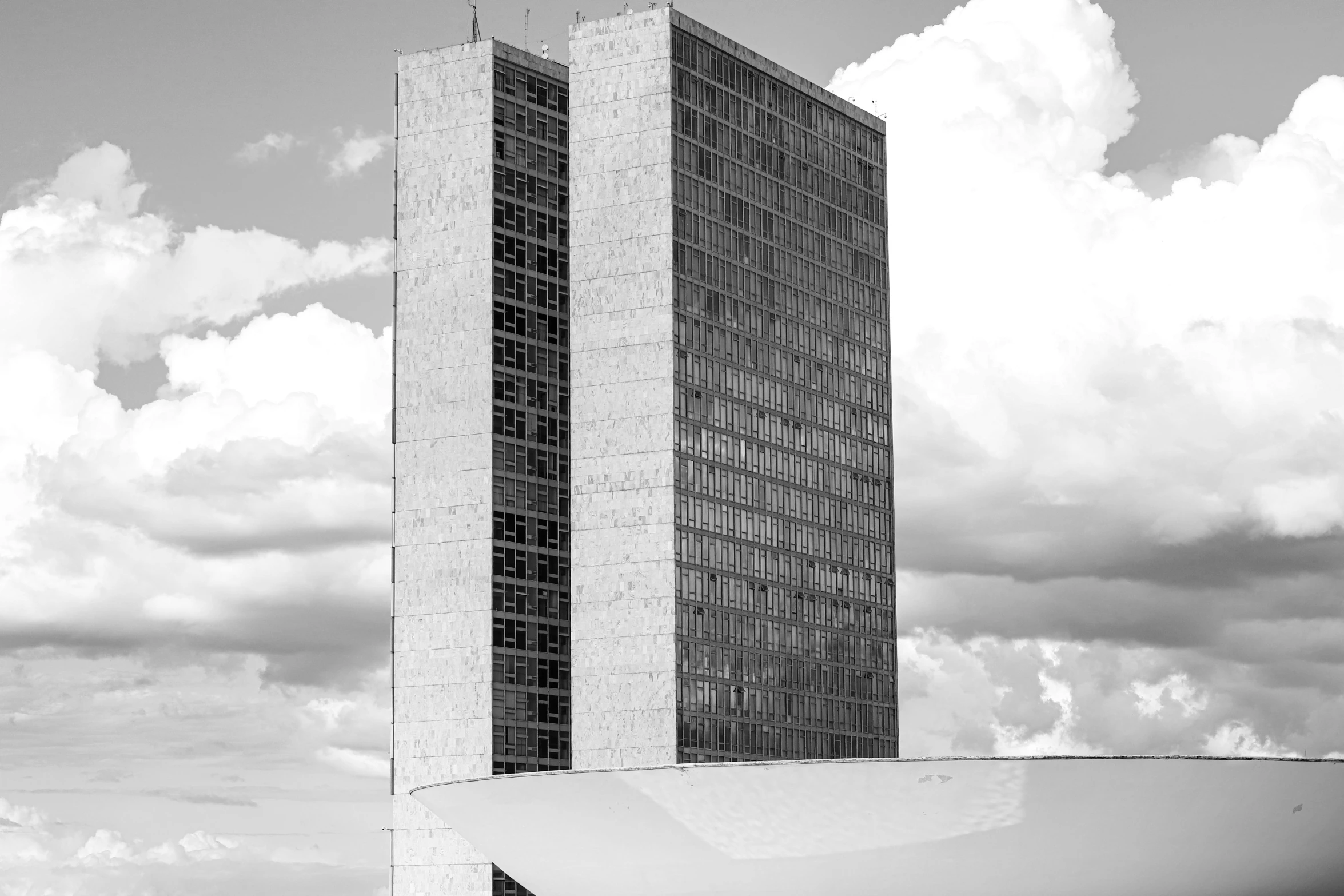 a black and white photo of a tall building, unsplash, brutalism, brazil, futuristic government chambers, on a bright day, cumulus