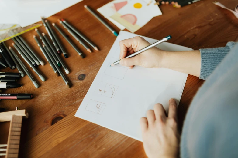 a person sitting at a table writing on a piece of paper, a drawing, trending on pexels, arbeitsrat für kunst, 9 9 designs, costume design made with love, background image