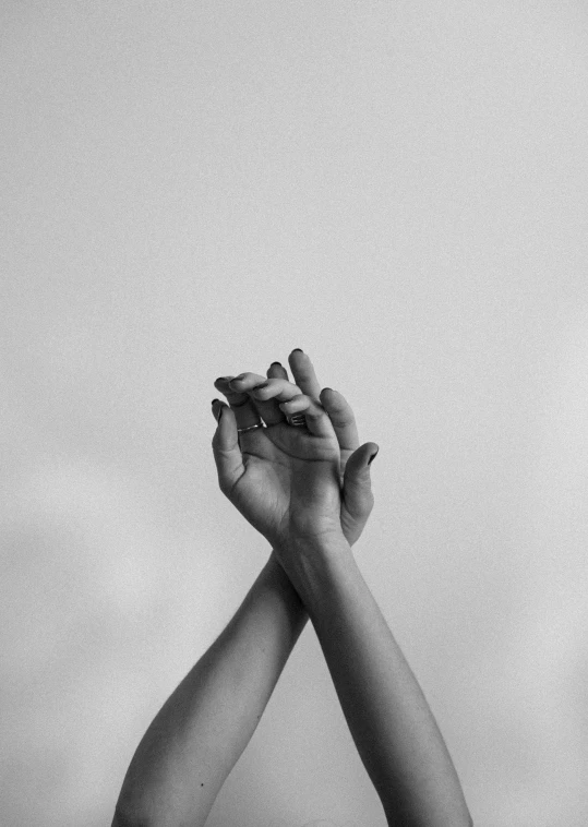 a black and white photo of two hands holding each other, a black and white photo, trending on pexels, ☁🌪🌙👩🏾, on grey background, jovana rikalo, hands up
