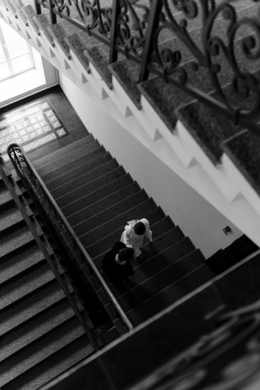 a person walking down a set of stairs, inspired by Henri Cartier-Bresson, in legnica city hall, private moment, f 2. 8 3 5 mm, egor letov