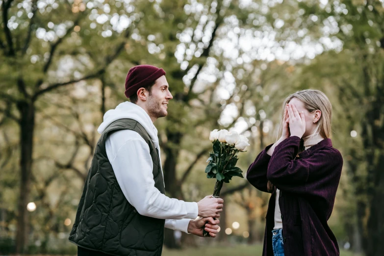 a man giving a woman a bouquet of flowers, by Niko Henrichon, pexels contest winner, 😭 🤮 💕 🎀, teenage girl, sydney hanson, outdoor photo