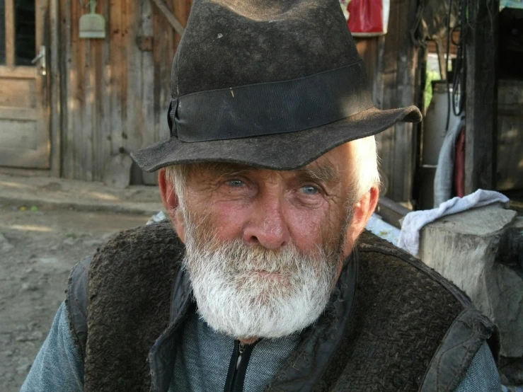a close up of a person wearing a hat, by Robert Storm Petersen, pexels contest winner, short white beard, on a farm, bosnian, australian
