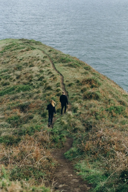 a couple of people that are standing on a hill, pexels contest winner, narrow footpath, on an island, walking on grass, flat lay