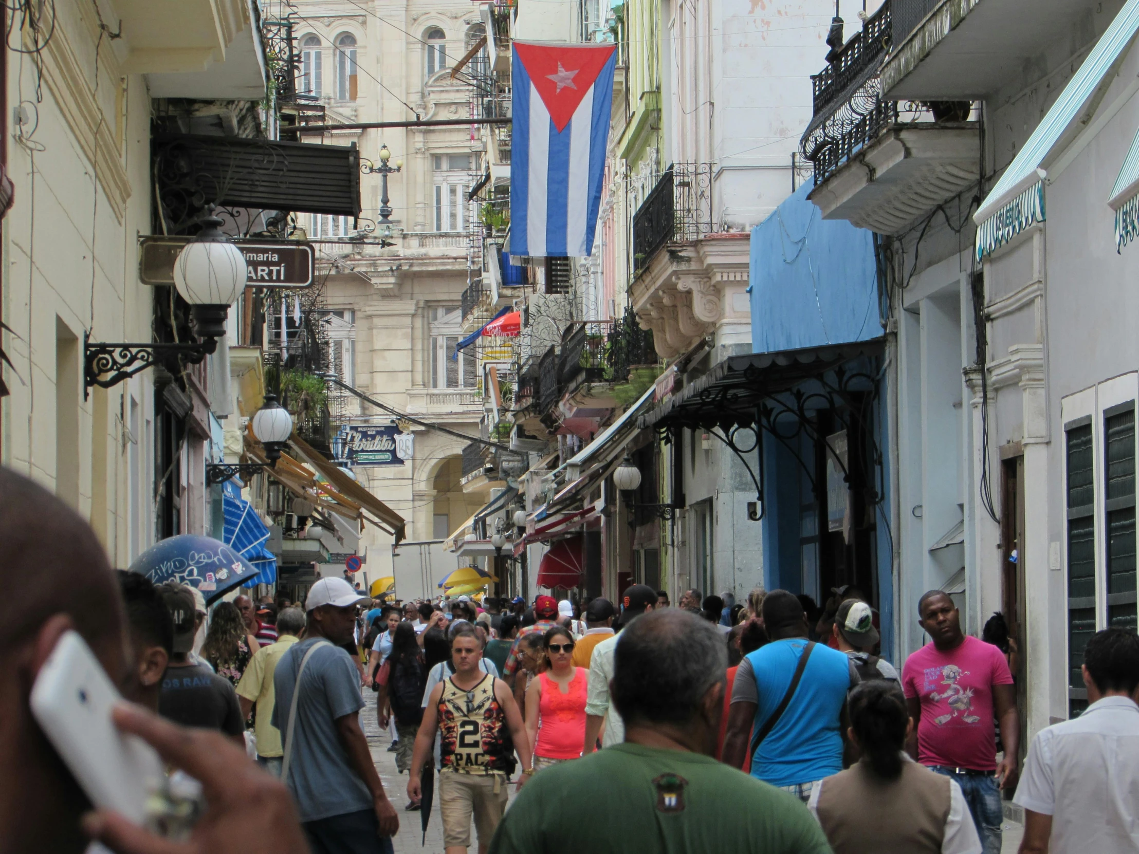 a crowd of people walking down a street next to tall buildings, cuban setting, square, thumbnail, crafts and souvenirs