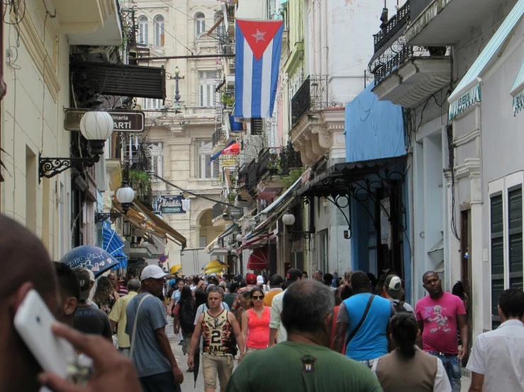a crowd of people walking down a street next to tall buildings, cuban setting, square, thumbnail, crafts and souvenirs