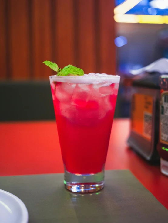 a close up of a drink in a glass on a table, profile image