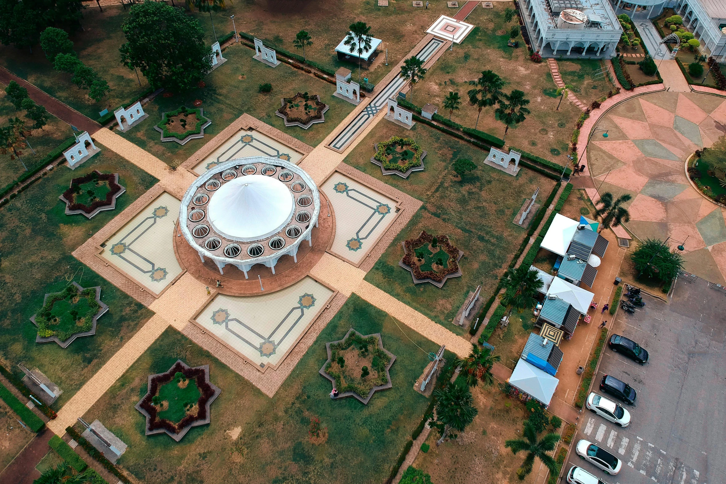 a large white dome sitting on top of a lush green field, pexels contest winner, visual art, shipibo, drone view of a city, celestial gardens, khedival opera house