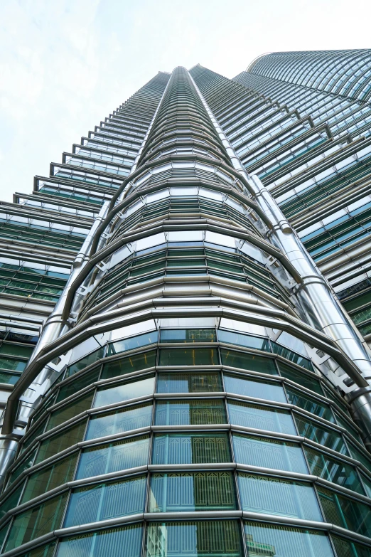 a very tall building with a lot of windows, inspired by Zaha Hadid, flickr, malaysian, with big chrome tubes, lots of glass details, ground-level view