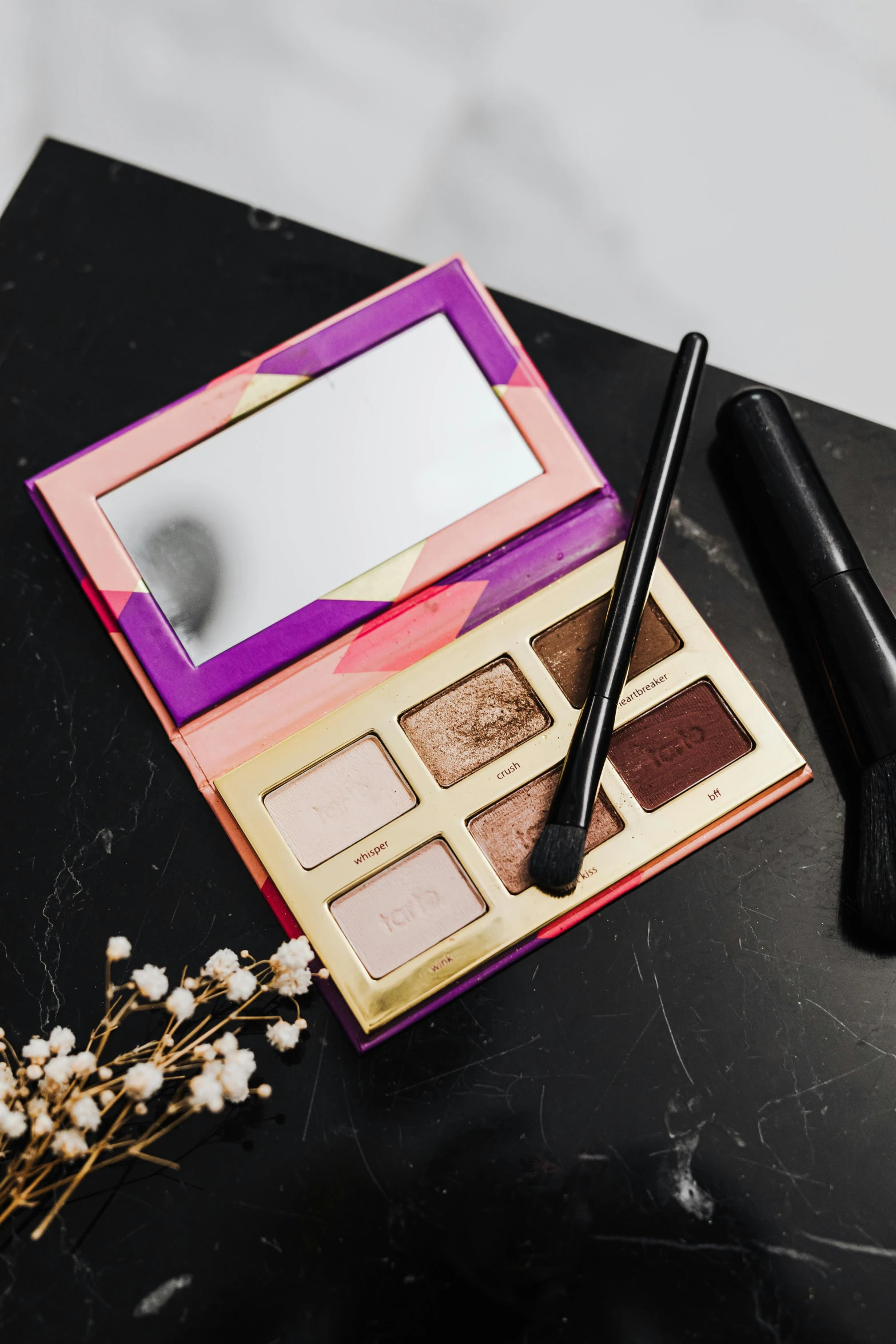 a makeup kit sitting on top of a table, by Julia Pishtar, golden fire palette, sleek purple eyes, high resolution product photo, moroccan