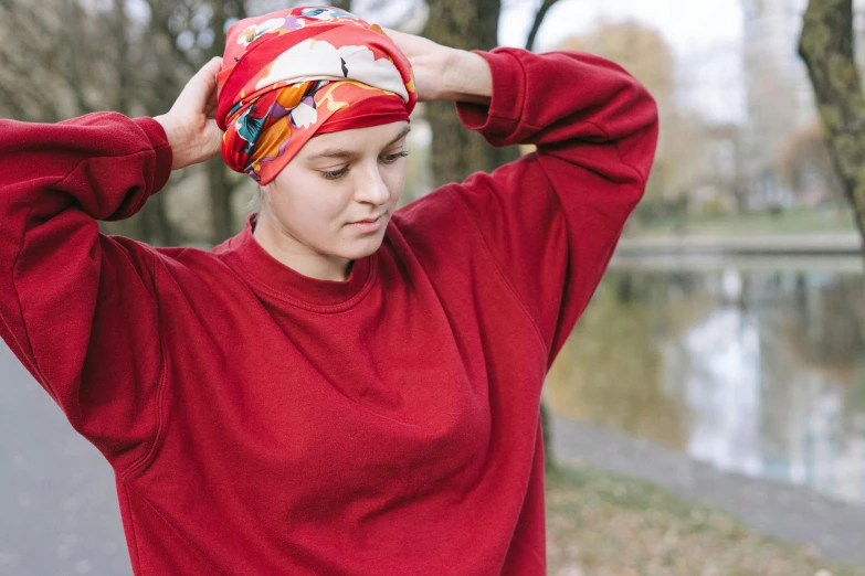 a woman in a red shirt and a red turban, by Nina Hamnett, unsplash, happening, calm weather, patterned clothing, greta thunberg, wearing a towel