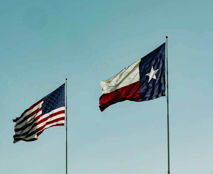 two american and texas flags flying side by side, a photo, by Carey Morris, pexels, visual art, multiple stories, 🚿🗝📝