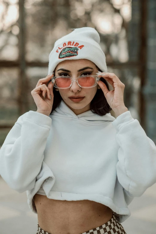 a woman wearing a white hat and sunglasses, a colorized photo, inspired by Elsa Bleda, trending on pexels, cute casual streetwear, hoodie, college, cold as ice! 🧊