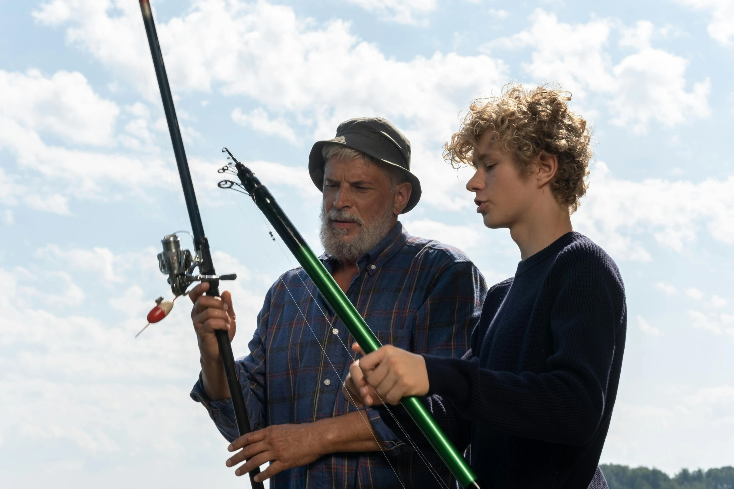 a man standing next to a boy holding a fishing rod, poster art, by Peter Churcher, pexels, high quality movie still, shot on 1 5 0 mm, an oldman, lachlan bailey