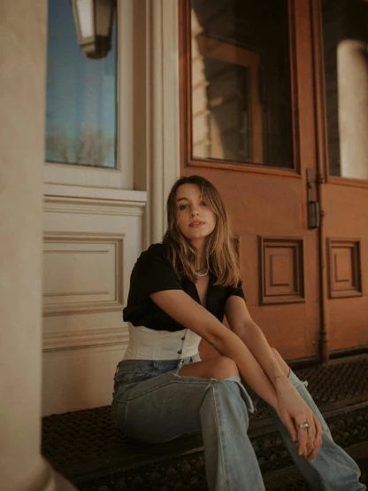 a woman sitting on the steps of a building, sydney sweeney, singer songwriter, high quality photo, ana de armas