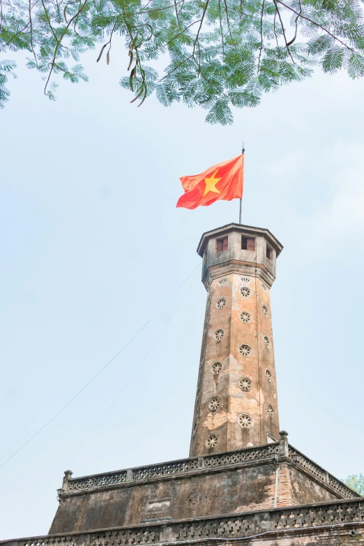 a building with a flag on top of it, hoang long ly, ventilation shafts, towering over your view, historic