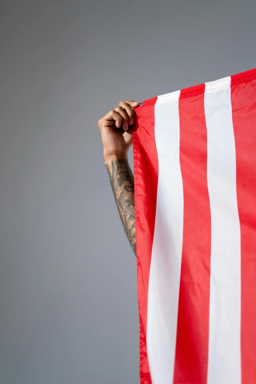 a man holding an american flag in front of his face, a tattoo, inspired by Oswaldo Viteri, red stripe, red cloth, lionel messi, 2019 trending photo