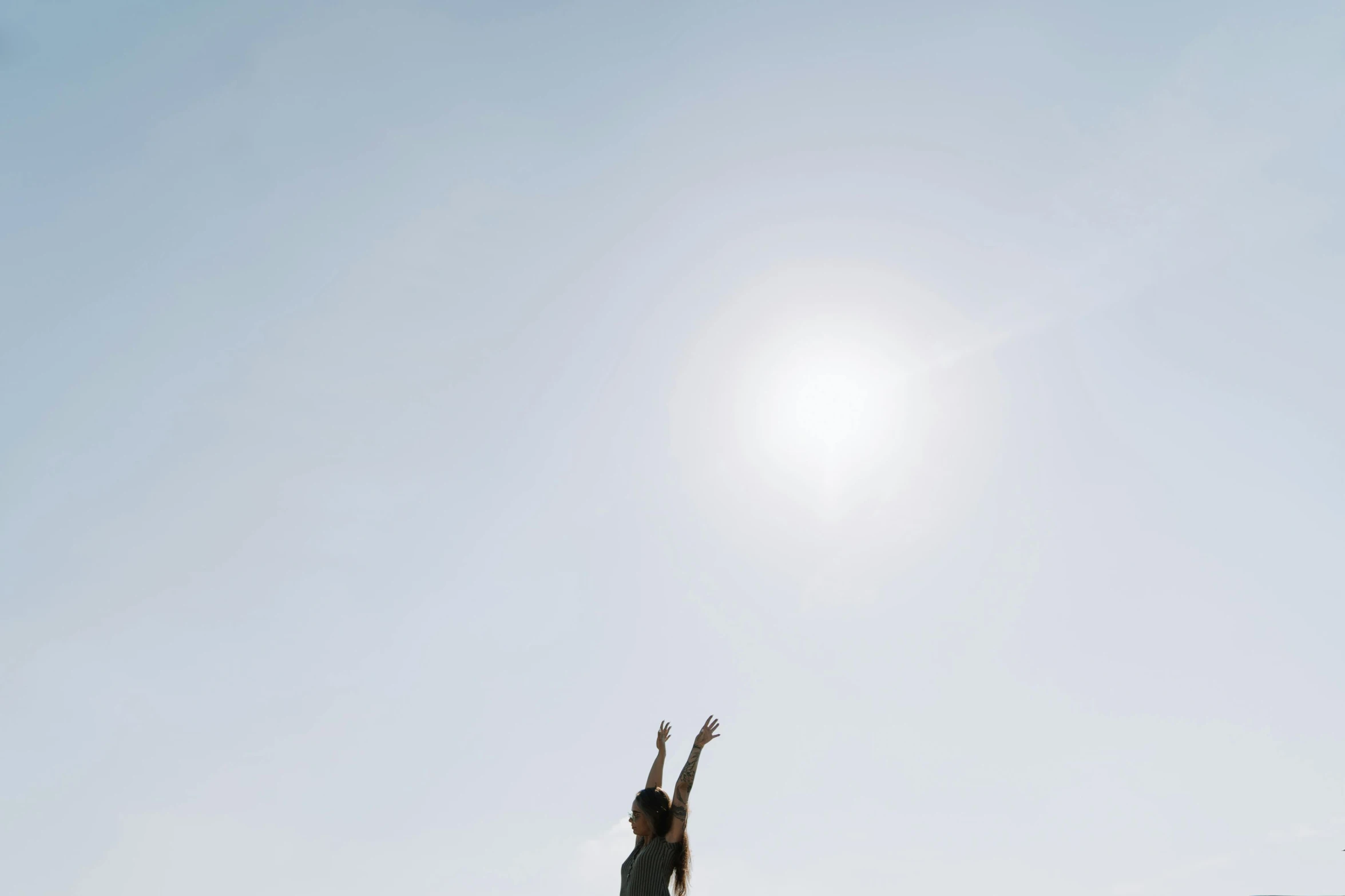 a woman reaching up into the sky to catch a frisbee, by Attila Meszlenyi, unsplash, light and space, sunny day with clear sky, yoga pose, promo image, minimalist photo