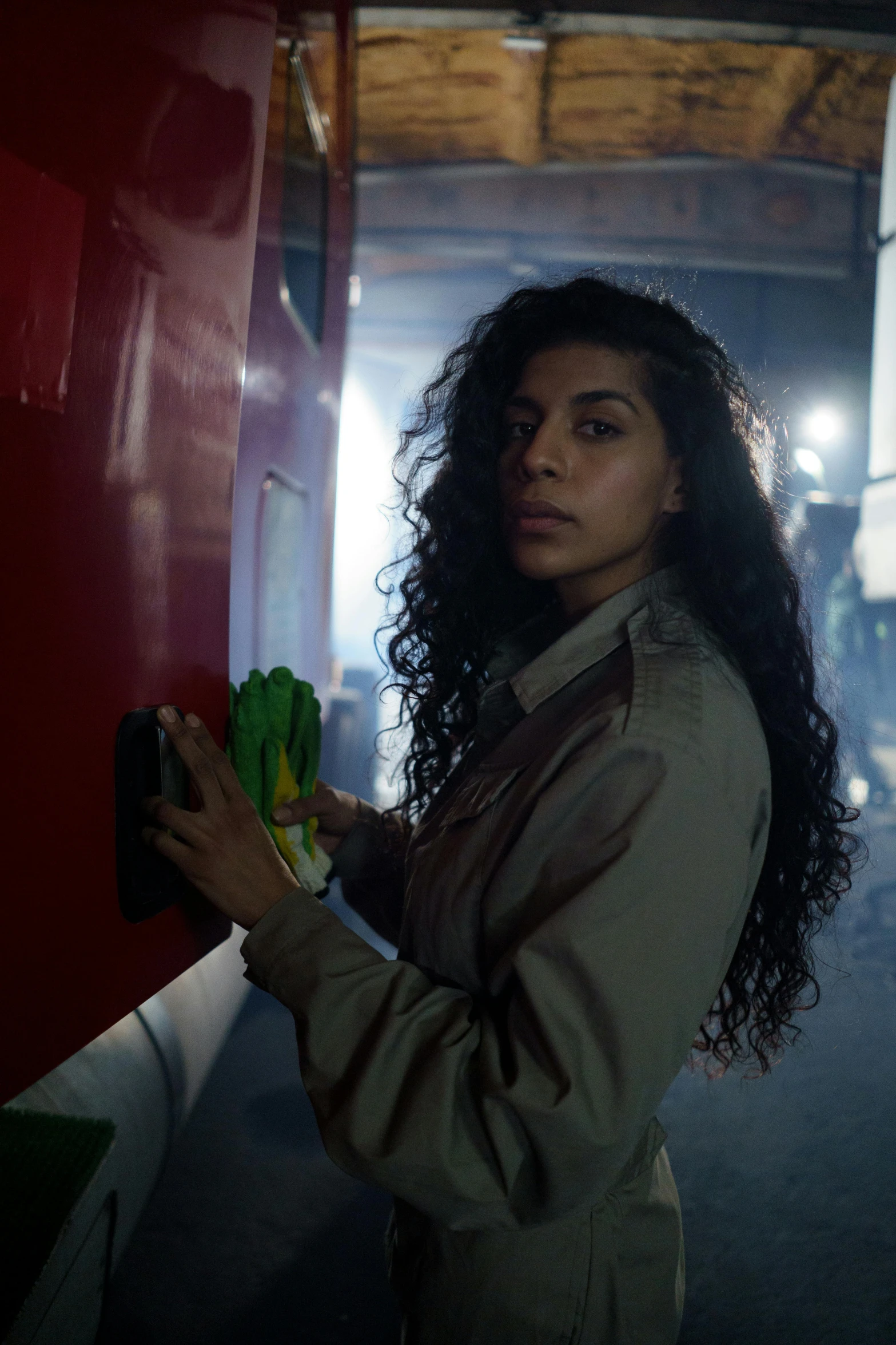 a woman standing in front of a red wall, an album cover, inspired by Nan Goldin, pexels contest winner, freida pinto, stood inside a futuristic lab, artist wearing overalls, still from the movie saw