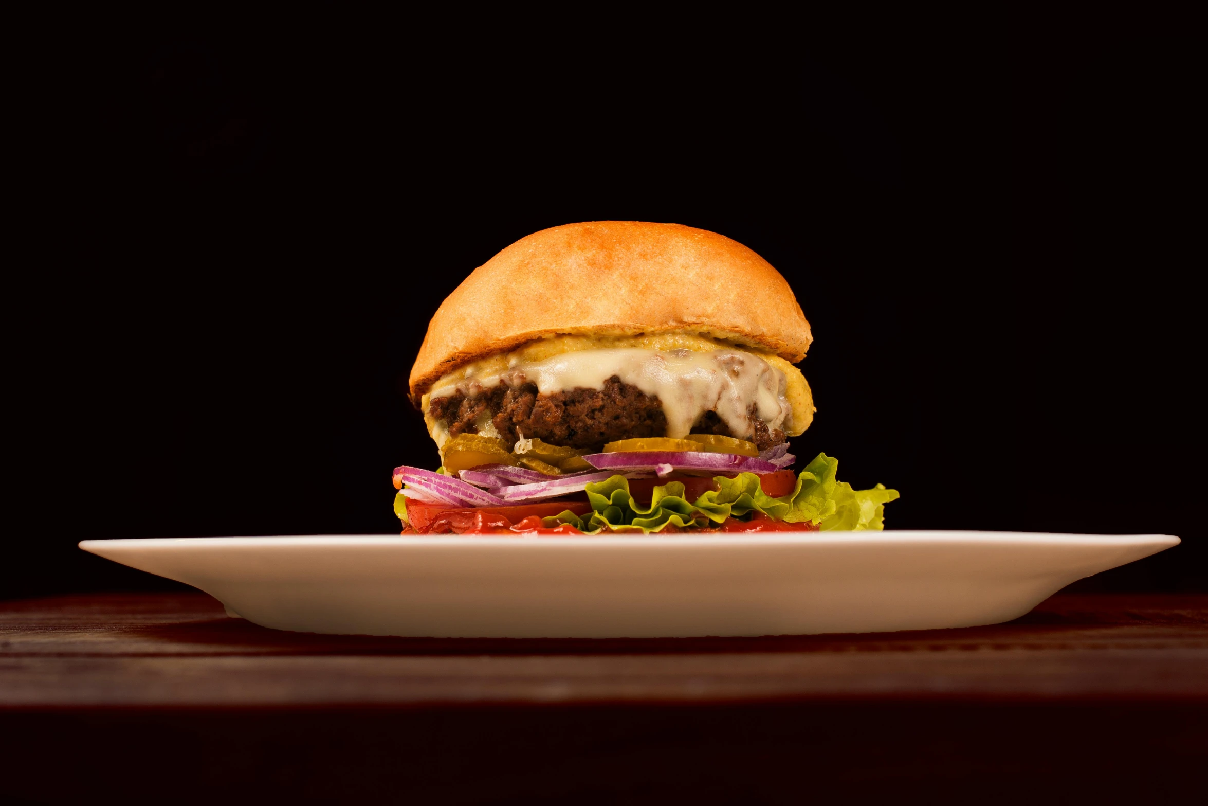 a hamburger sitting on top of a white plate, in front of a black background, profile image, restaurant exterior photography, thumbnail