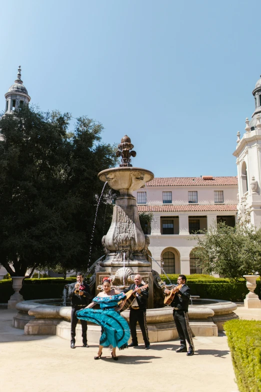 a group of people standing around a fountain, a statue, inspired by Luis Paret y Alcazar, rococo, cupertino, sitting in a castle, wearing a dress made of water, victorian buildings