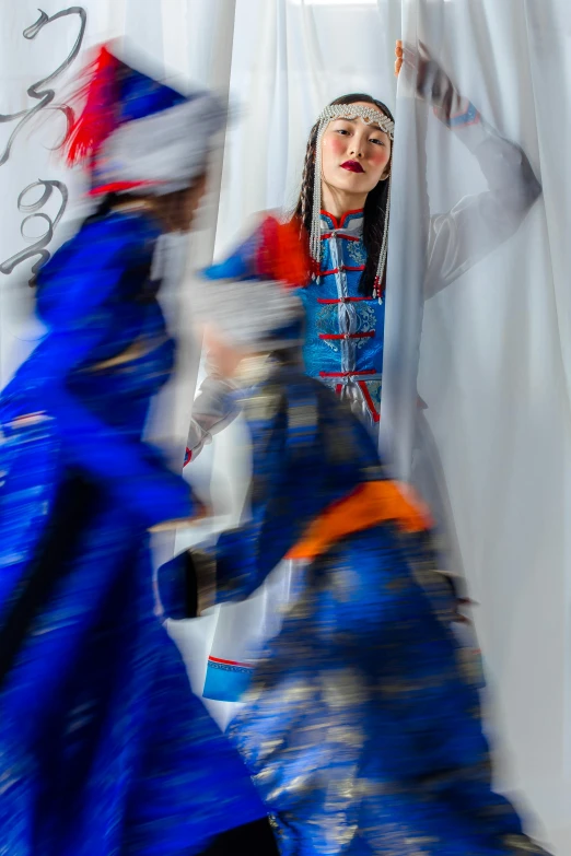 a couple of people that are standing in front of a curtain, inspired by Qian Gu, arabesque, costume with blue accents, motion blured movement, shot with sony alpha, mongolia