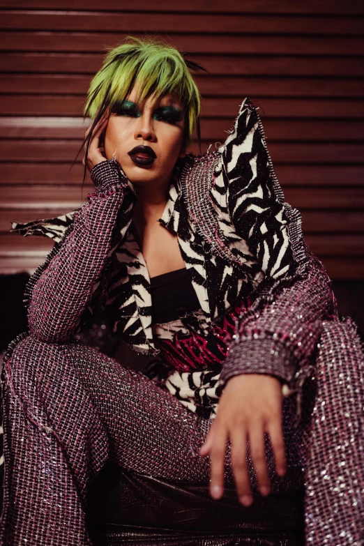 a woman with green hair sitting on a couch, an album cover, inspired by Aya Goda, trending on pexels, wearing disco suit, aggressive look, haute couture fashion shoot, patterned clothing