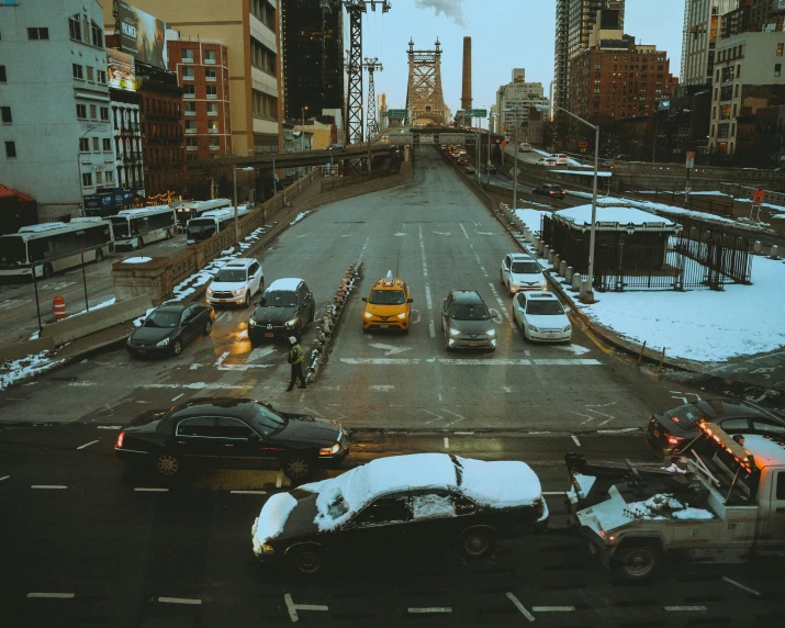 a street filled with lots of traffic next to tall buildings, an album cover, inspired by Thomas Struth, pexels contest winner, realism, new - york skyline in winter, bridge, cars, cold winter