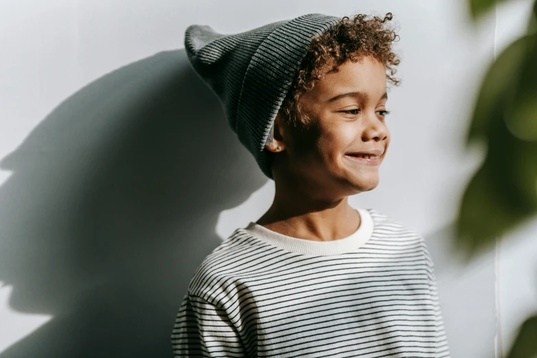 a young boy wearing a striped shirt and a beanie, pexels contest winner, sunbeam, white and black clothing, happy fashion model, thumbnail