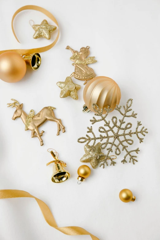 gold christmas ornaments on a white surface, a still life, inspired by Rudolph F. Ingerle, trending on pexels, made of gold, collection product, ornamentation, 8