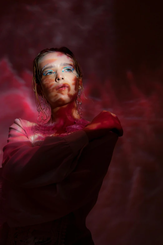 a woman with red paint on her face, an album cover, inspired by Anna Füssli, iridescent smoke behind, cyborg fashion model, concert photo, view from the bottom