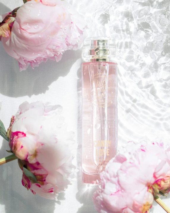 a bottle of perfume next to some pink flowers, inspired by Elsie Few, featured on instagram, fine lace, shot from the side, product view, vibrating