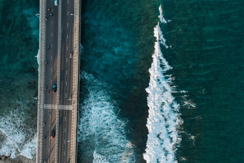 an aerial view of a highway next to the ocean, pexels contest winner, renaissance, wall of water either side, manly, on a bridge, surfing