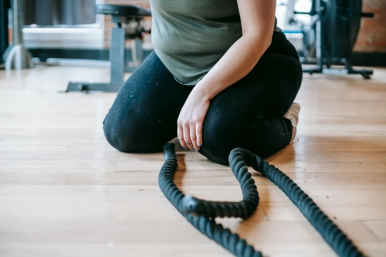 a woman sitting on the floor with a rope, pexels contest winner, local gym, pregnant belly, lachlan bailey, profile image