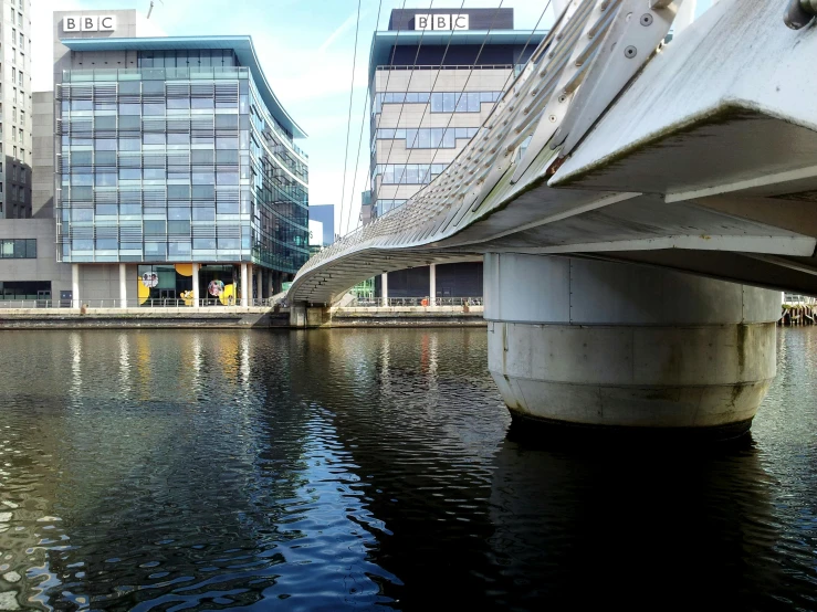 a bridge over a body of water next to tall buildings, inspired by Richard Wilson, flickr, happening, channel 4, manchester, curvy build, gopro photo