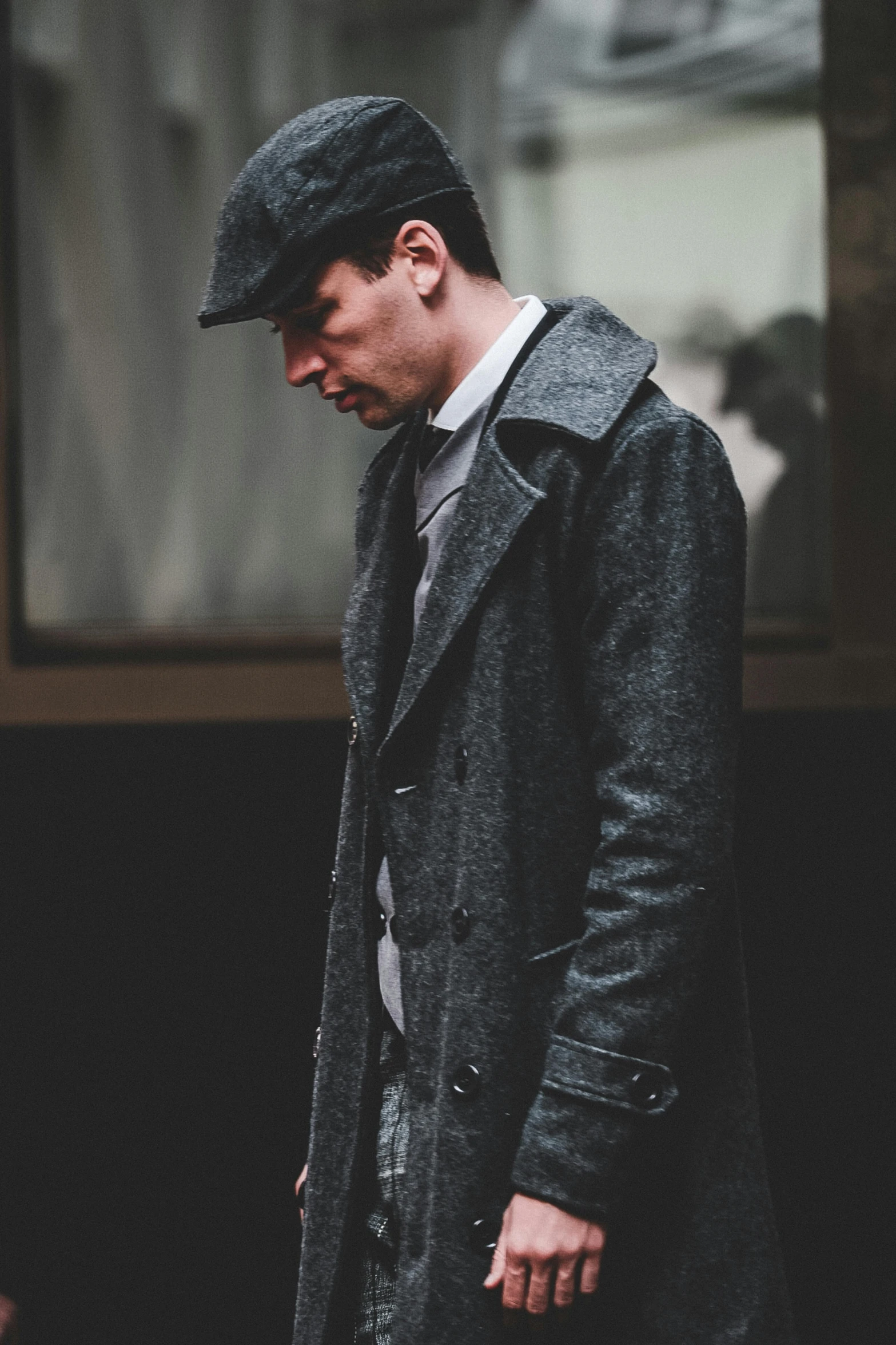 a man in a coat is walking down the street, a portrait, inspired by Max Magnus Norman, unsplash, bauhaus, costumes from peaky blinders, thumbnail, gunmetal grey, full product shot