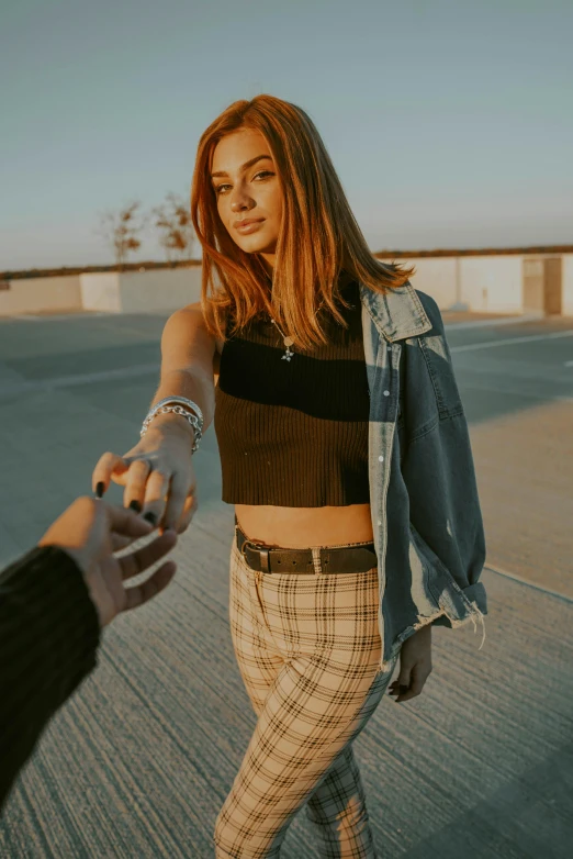 a woman holding a man's hand on the side of a road, inspired by Elsa Bleda, trending on pexels, renaissance, wearing crop top and miniskirt, on rooftop, teenage girl, cropped shirt with jacket