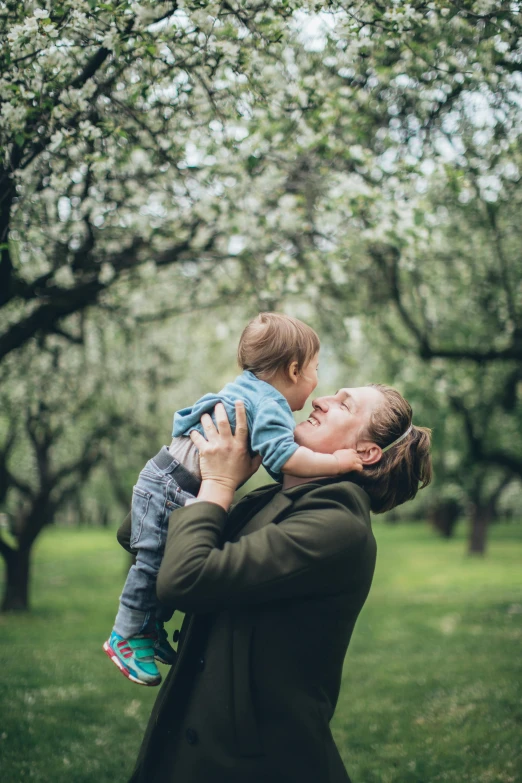 a woman holding a small child in her arms, pexels contest winner, apple trees, all overly excited, swedish, profile image